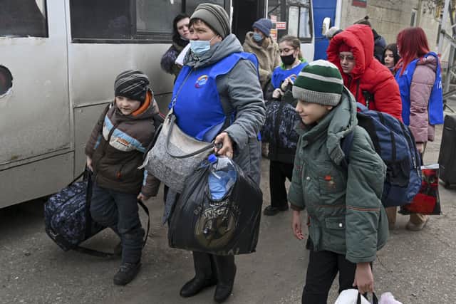 People evacuated from the Donetsk and Luhansk regions, the territory controlled by a pro-Russia separatist in eastern Ukraine, leave a bus to be taken to temporary residences in other regions of Russia.