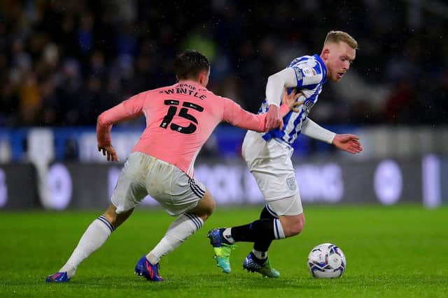 Huddersfield Town captain Lewis O'Brien shields the ball from Cardiff rival Ryan Wintle. Picture: PA