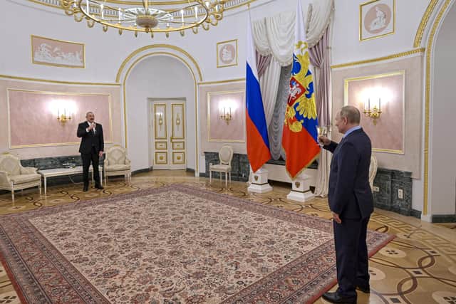 Russian President Vladimir Putin, right, toasts with Azerbaijani President Ilham Aliyev after their talks in the Kremlin in Moscow.