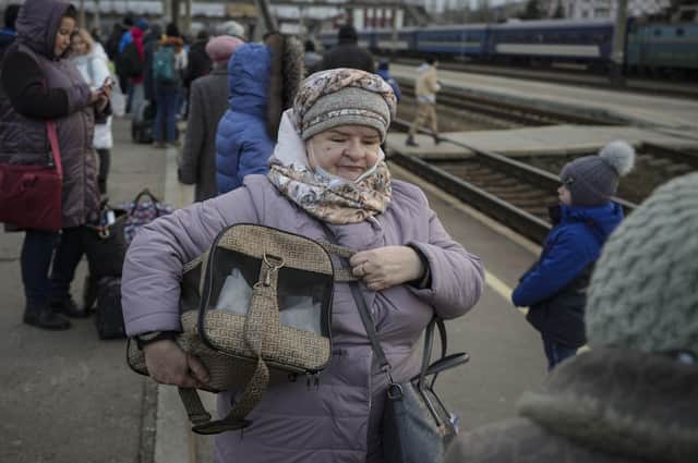 An elderly lady holds a pet carrier while waiting for a Kyiv bound train on a platform in Kramatorsk, the Donetsk region, eastern Ukraine,  as Russia's invasion intensified.
