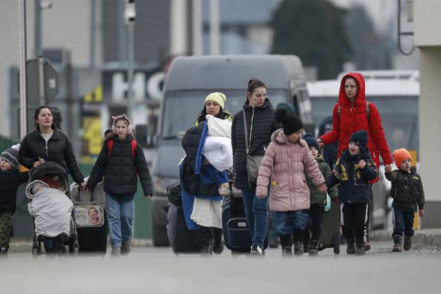 Refugees fleeing conflict in Ukraine arrive at the Medyka border crossing, in Poland, Sunday, Feb. 27, 2022.