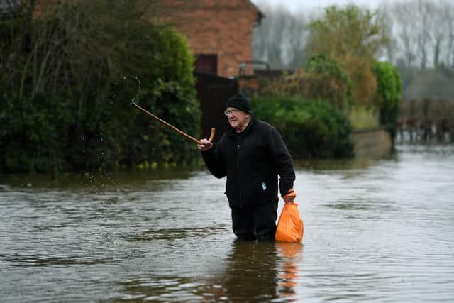 Mick Malkinson wades through flood water at his house near Tadcaster Albion Football ground after the River Wharfe flooded the town. 22nd February 2022. Picture : Jonathan Gawthorpe