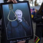 A demonstrator holds a placard depicting a Russia's President Vladimyr Putin as he attends a protest against the Russian invasion of Ukraine in front of the Russian embassy in Vilnius, Lithuania. (AP Photo/Mindaugas Kulbis).