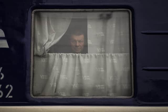 A man looks out of the Dnipro-Truskavets train, at the Lviv railway station, Sunday, Feb. 27, 2022, in Lviv, west Ukraine. The U.N. has estimated the conflict could produce as many as 4 million refugees. (AP Photo/Bernat Armangue).