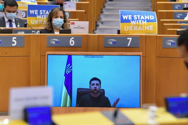 Ukrainian President Volodymyr Zelensky appears on a screen as he speaks in a video conference during a special plenary session of the European Parliament focused on the Russian invasion of Ukraine at the EU headquarters in Brussels.