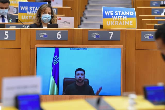 Ukrainian President Volodymyr Zelensky appears on a screen as he speaks in a video conference during a special plenary session of the European Parliament focused on the Russian invasion of Ukraine at the EU headquarters in Brussels, on March 01, 2022. - The European Commission has opened the door for Ukraine to join the EU, but this is not for tomorrow, despite Kiev's request for a special procedure to integrate the country "without delay". (Photo by JOHN THYS / AFP) (Photo by JOHN THYS/AFP via Getty Images).