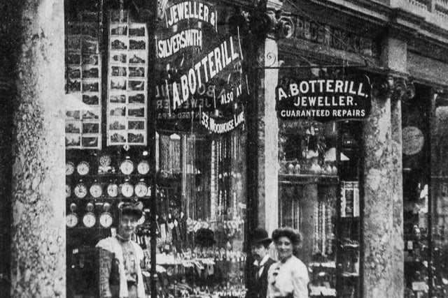 Two women stand outside a jewellers in the city.