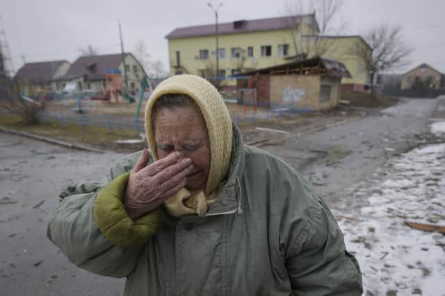 A woman cries outside houses damaged by a Russian airstrike, according to locals, in Gorenka, outside the capital Kyiv, Ukraine, Wednesday, March 2, 2022. (AP Photo/Vadim Ghirda)