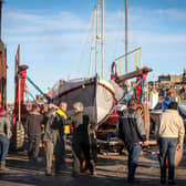 The old lifeboat, Robert and Ellen Robson, is lowered onto the restored carriage at Coates Marine, Whitby. Credit: RNLI/Ceri Oakes