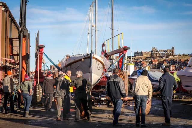 The old lifeboat, Robert and Ellen Robson, is lowered onto the restored carriage at Coates Marine, Whitby. Credit: RNLI/Ceri Oakes