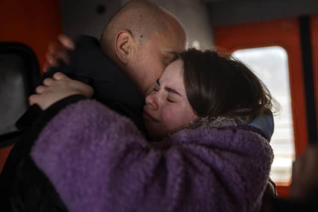 A couple say their good-byes on a train bound for Lviv at the Kyiv station, Ukraine, Thursday, March 3, 2022. Ukrainian men have to stay to fight in the war while women and children are leaving the country to seek refuge in a neighbouring country. (AP Photo/Emilio Morenatti).