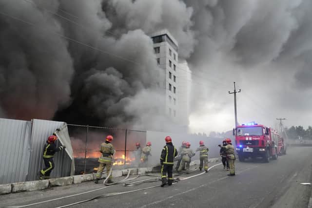 Firefighters work to extinguish a fire at a damaged logistic center after shelling in Kyiv, Ukraine, Thursday, March 3, 2022. Russian forces have escalated their attacks on crowded cities in what Ukraine's leader called a blatant campaign of terror. (AP Photo/Efrem Lukatsky)