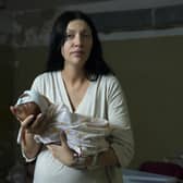 A woman, who did not want to be identified, poses for a photograph as she holds her newborn girl in the basement of a maternity hospital converted into a medical ward and used as a bomb shelter during air raid alerts, in Kyiv, Ukraine, Wednesday, March 2, 2022. Russian forces have escalated their attacks on crowded cities in what Ukraine's leader called a blatant campaign of terror. (AP Photo/Efrem Lukatsky).