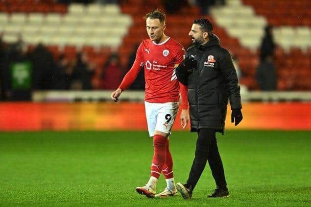 Barnsley head coach Poya Asbaghi, pictured in discussion with captain Cauley Woodrow.