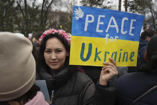 A demonstrator holds a poster reading "Peace for Ukraine!" during a protest against the Russian military invasion in Ukraine in Almaty, Kazakhstan, Sunday, March 6, 2022. (AP Photo/Vladimir Tretyakov).