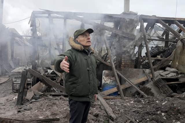 A man opens his arms as he stands near a house destroyed in the Russian artillery shelling, in the village of Horenka close to Kyiv, Ukraine, Sunday, March 6, 2022. On Day 11 of Russia's war on Ukraine, Russian troops shelled encircled cities, and it appeared that a second attempt to evacuate civilians from the besieged port city of Mariupol had failed due to continued violence. (AP Photo/Efrem Lukatsky).