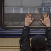 Aleksander, 41, presses his palms against the window as he says goodbye to his daughter Anna, 5, on a train to Lviv at the Kyiv station, Ukraine, Friday, March 4. 2022. Aleksander has to stay behind to fight in the war while his family leaves the country to seek refuge in a neighbouring country. (AP Photo/Emilio Morenatti).