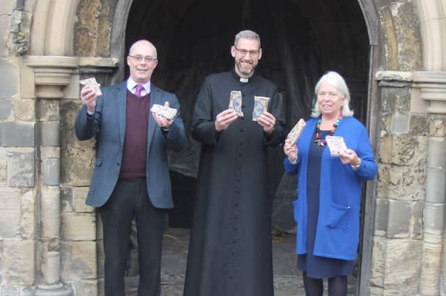 Churchwardens Nigel Laws, Rev Jake Belder and Tina Lumley show some of the broken tiles.