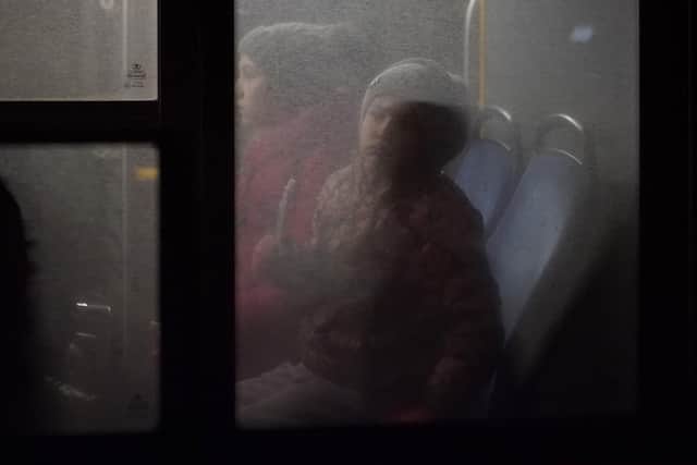 Refugees fleeing war in neighboring Ukraine ride on a bus after crossing to Medyka, Poland, Wednesday, March 9, 2022. (AP Photo/Daniel Cole).