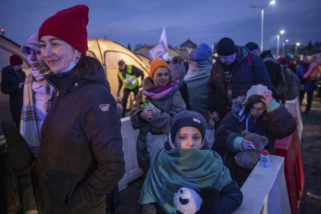 Women and children gather around a bonfire before they board a train heading for Krakow, after fleeing from Ukraine, at the border crossing in Medyka, Poland, Wednesday, March 9, 2022. U.N. officials said that the Russian onslaught has forced 2 million people to flee Ukraine. It has trapped others inside besieged cities that are running low on food, water and medicine amid the biggest ground war in Europe since World War II. (AP Photo/Visar Kryeziu).