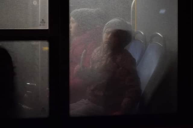 Refugees fleeing war in neighboring Ukraine ride on a bus after crossing to Medyka, Poland, Wednesday, March 9, 2022. (AP Photo/Daniel Cole).
