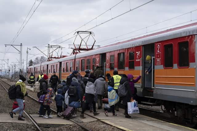 Women and children board a train heading to Krakow after fleeing Ukraine, at the border crossing in Medyka, Poland, Thursday, March 10, 2022. U.N. officials said that the Russian onslaught has forced 2 million people to flee Ukraine. (AP Photo/Petros Giannakouris).