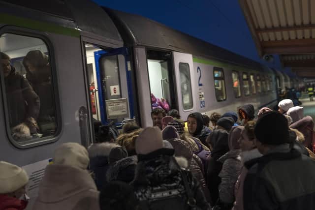 Ukrainian refugees embark a train bound to Warsaw, at the Przemysl train station, southeastern Poland, on Friday, March 11, 2022. Thousands of people have been killed and more than 2.3 million have fled the country since Russian troops crossed into Ukraine on Feb. 24. (AP Photo/Petros Giannakouris).