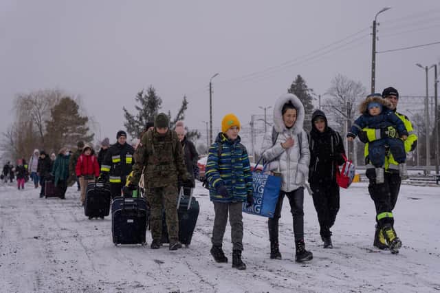 Ukrainian refugees wait for a train after crossing the border during snowfall to Medyka, Poland. Picture: Adam Gray/SWNS.