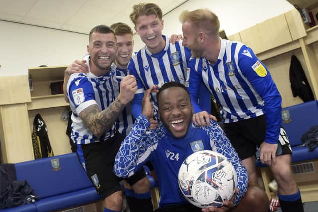 All smiles: Saido Berahino celebrates with the match ball and his Sheffield Wednesday team-mates in the dressing room after their 6-0 win over Cambridge United. (Picture: Steve Ellis)