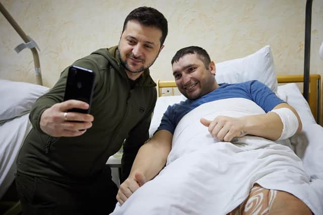 In this photo provided by the Ukrainian Presidential Press Office on Sunday, March 13, 2022, President Volodymyr Zelenskyy, left, takes a picture with a wounded soldier during his visit to a hospital in Kyiv, Ukraine. (Ukrainian Presidential Press Office via AP).