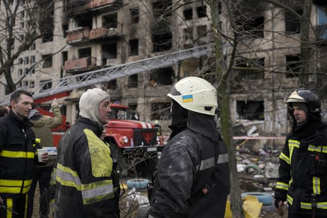 Ukrainian firefighters work in a resident building after it was hit by artillery shelling in Kyiv, Ukraine, Monday, March 14, 2022. (AP Photo/Vadim Ghirda).