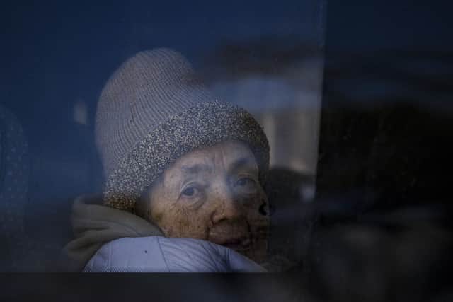 A refugee fleeing the war from neighbouring Ukraine looks out a bus window after crossing the border, at the Romanian-Ukrainian border, in Siret, Romania, Monday, March 14, 2022. (AP Photo/Andreea Alexandru).