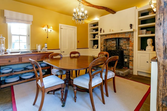 The dining room with wood-burning stove is cosy and furnished in keeping with the property's heritage