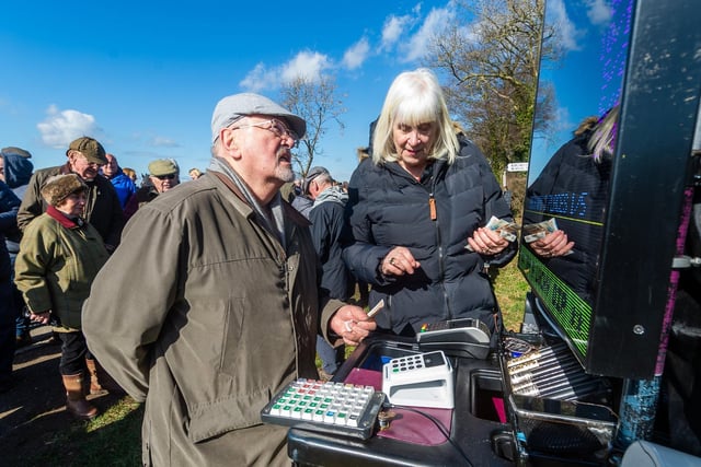 A spectator places bets with the course's only bookmaker