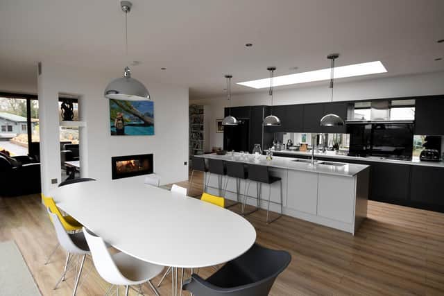 The open-plan living space with chimney breast and its log burning fire cleverly dividing the kitchen/dining arae and the sitting area