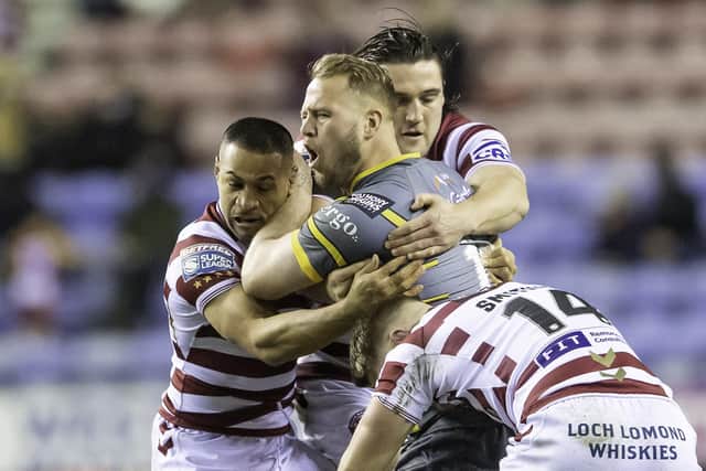 Picture by Allan McKenzie/SWpix.com - 17/03/2022 - Rugby League - Betfred Super League Round 6 - Wigan Warriors v Castleford Tigers - DW Stadium, Wigan, England - Castleford's Joe Westerman is tackled by Wigan's WIllie Isa, Liam Byrne & Morgan Smithies.