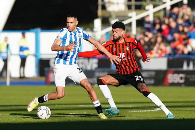 HOME DEFEAT: Huddersfield Town's Jon Russell (left) and Bournemouth's Philip Billing battle for the ball during the Sky Bet Championship match at the John Smith's Stadium. Picture: Martin Rickett/PA Wire.