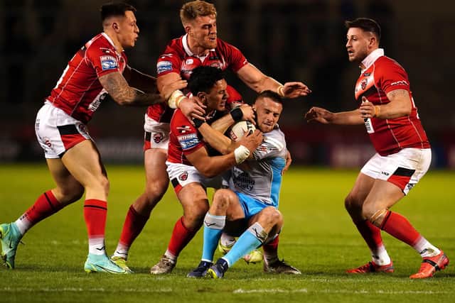 Leeds Rhinos' Jack Walker (right) is tackled by Salford Red Devils' Elijah Taylor at the Emerald Headingley . Picture: Martin Rickett/PA