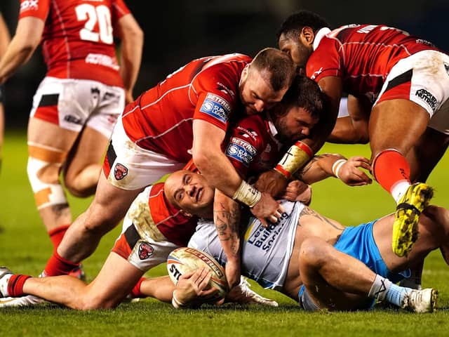 BAD NIGHT: Leeds Rhinos' Bodene Thompson is tackled by Salford Red Devils' Greg Burke, Andy Ackers and King Vuniyayawa Picture: Martin Rickett/PA