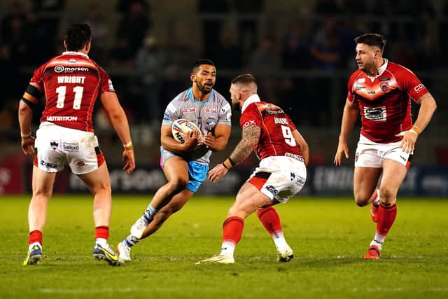 Leeds Rhinos' Kruise Leeming is tackled by Salford Red Devils' Andy Ackers Picture: Martin Rickett/PA