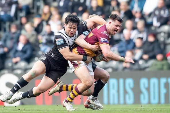 Huddersfield's Joe Greenwood is tackled by Andre Savelio, of Hull. Picture by Allan McKenzie/SWpix.com.