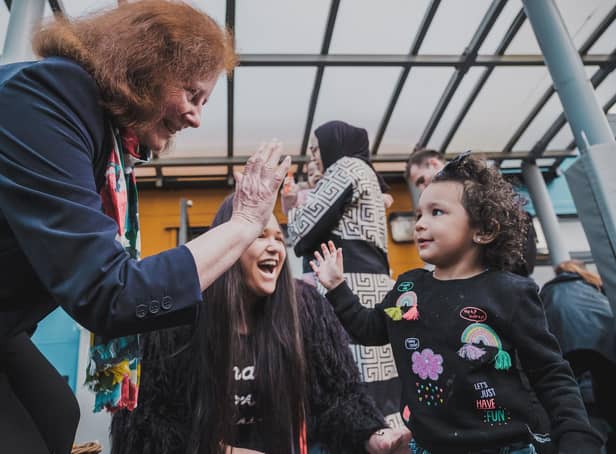 Welsh Government deputy minister for social services Julie Morgan high-fives a child in celebration of the new law banning the physical punishment of children. Welsh Government/PA Wire