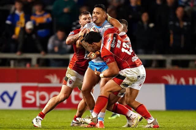 Leeds Rhinos' Zane Tetevano is tackled by Salford Red Devils' Elijah Taylor (right) and Ryan Lannon during the Betfred Super League match at the Emerald Headingley Stadium, Leeds. Picture date: Friday March 18, 2022. PA Photo. See PA story RUGBYL Salford. Photo credit should read: Martin Rickett/PA Wire.

RESTRICTIONS: Use subject to restrictions. Editorial use only, no commercial use without prior consent from rights holder.
