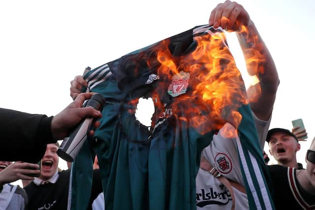 Fans burn a Liverpool replica shirt outside Elland Road against Liverpool's decision to be included amongst the clubs attempting to form a new European Super League. (Picture: PA)