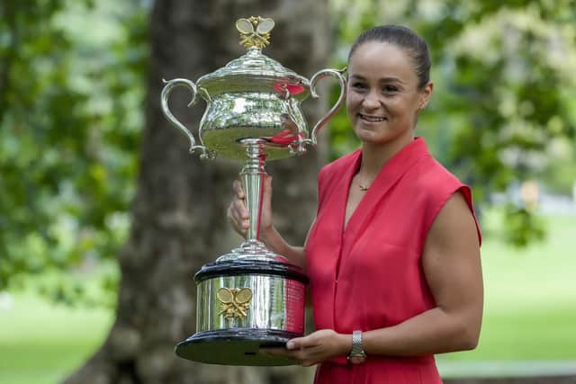 Ash Barty of Australia poses with the Daphne Akhurst Memorial Cup at a park, the morning after defeating Danielle Collins of the U.S. in the women's singles final at the Australian Open tennis championships in Melbourne on Jan. 30, 2022. In a shock announcement Wednesday, March 23, 2022, No. 1-ranked Barty announced her retirement from tennis. (AP Photo/Mark Baker)