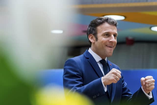 French President Emmanuel Macron gestures as he arrives for a round table meeting at an EU summit in Brussels.
