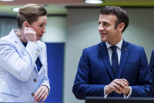 French President Emmanuel Macron, right, speaks with Denmark's Prime Minister Mette Frederiksen as he arrives for a round table meeting at an EU summit in Brussels.