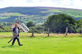 Committee Member John Helm getting the Egton Show signs out of the store ready for the Egton show with a backdrop of the North York Moors