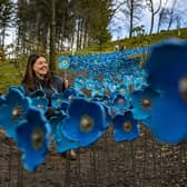 Artist Anna Whitehouse with 80 square metre land art made from 1,300 blue ceramic poppies - cascading down the hillside at the Himalayan Garden at Grewelthorpe near Ripon.