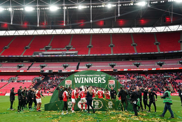 Rotherham players and staff celebrate on the pitch at Wembley.